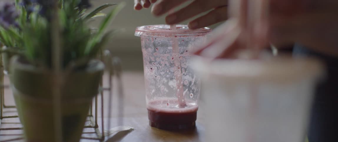 Women play with the straws in their plastic cups