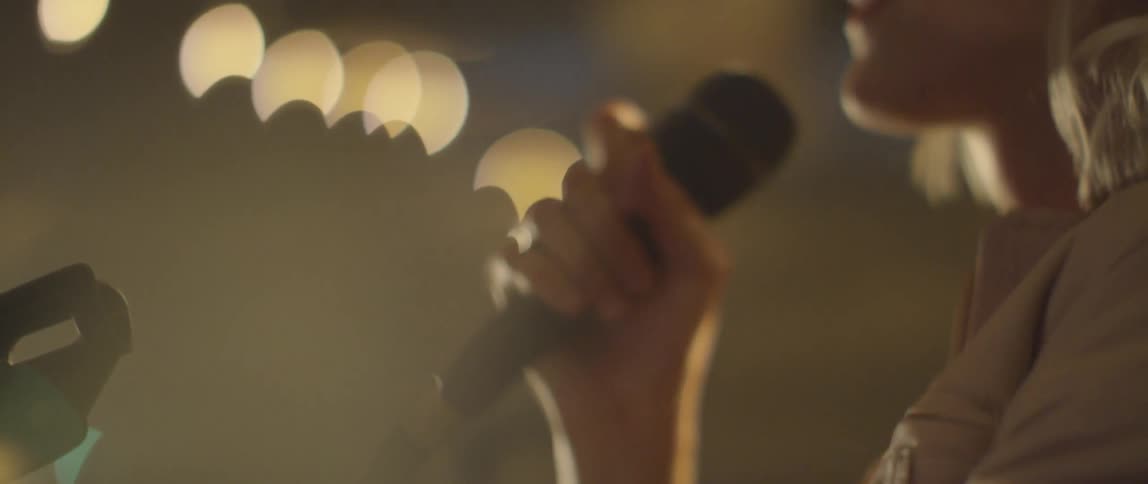 A woman performs karaoke at a karaoke bar