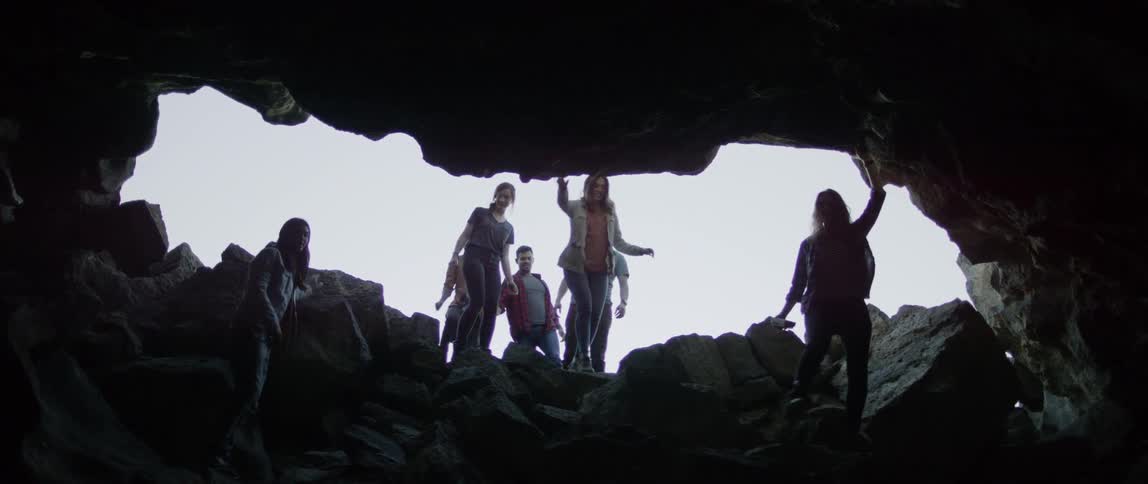 A group of people descend into a cave