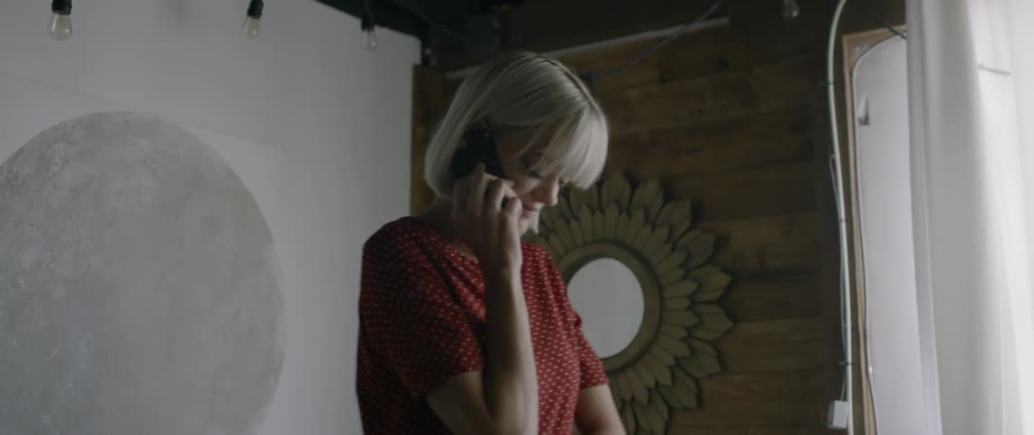 A woman talks on the phone while standing