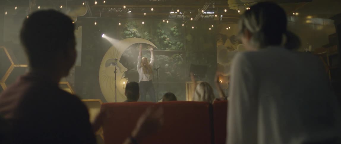 An audience claps along with a singer