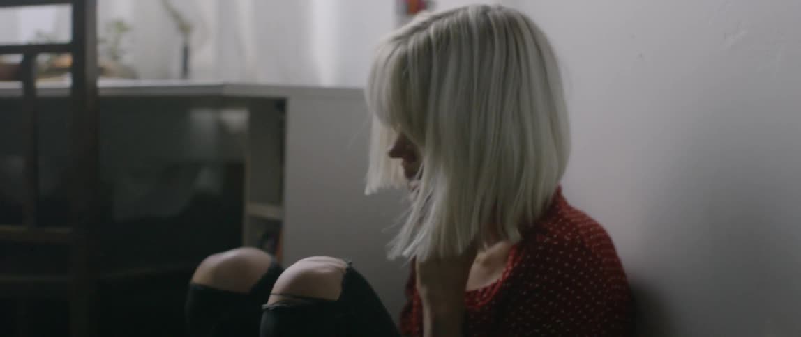 A woman sits curled up while talking on the phone