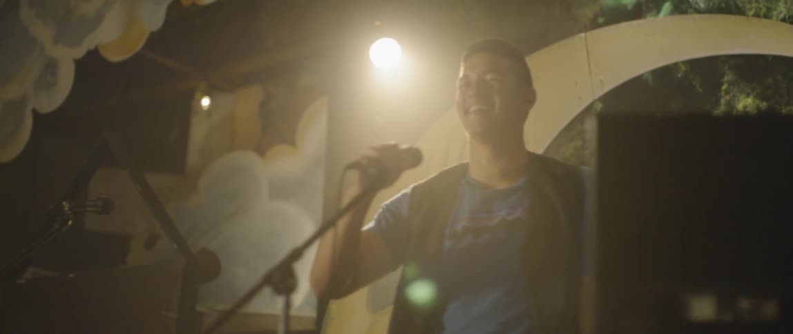 A man excitedly hops on stage to perform karaoke