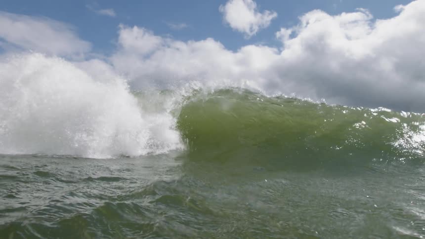 The large wave moves and splashes in the water