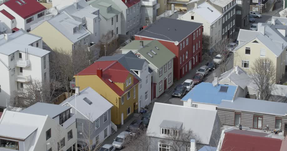 People are walking on a sidewalk in a neighborhood during the day