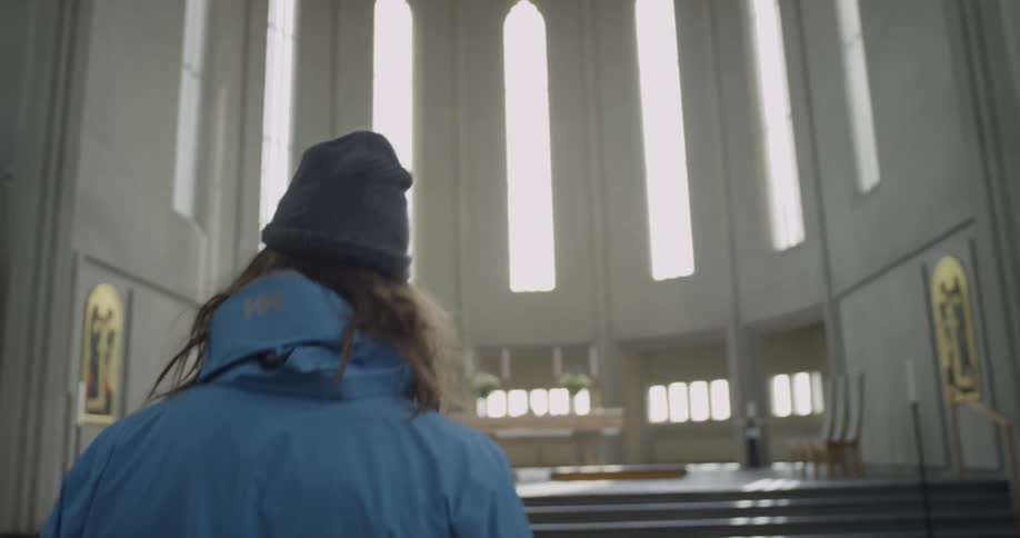 A long haired man walking into a church