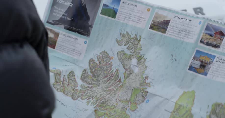 A man unfolds a map outside