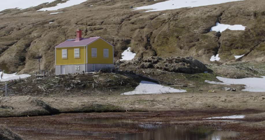 A yellow house is by the mountain