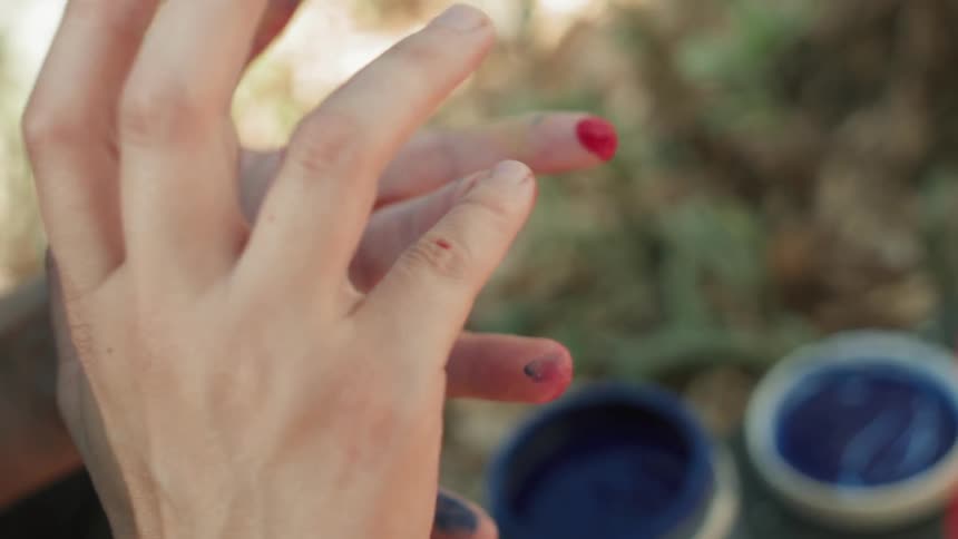 Some people are using their hands to play with some paint