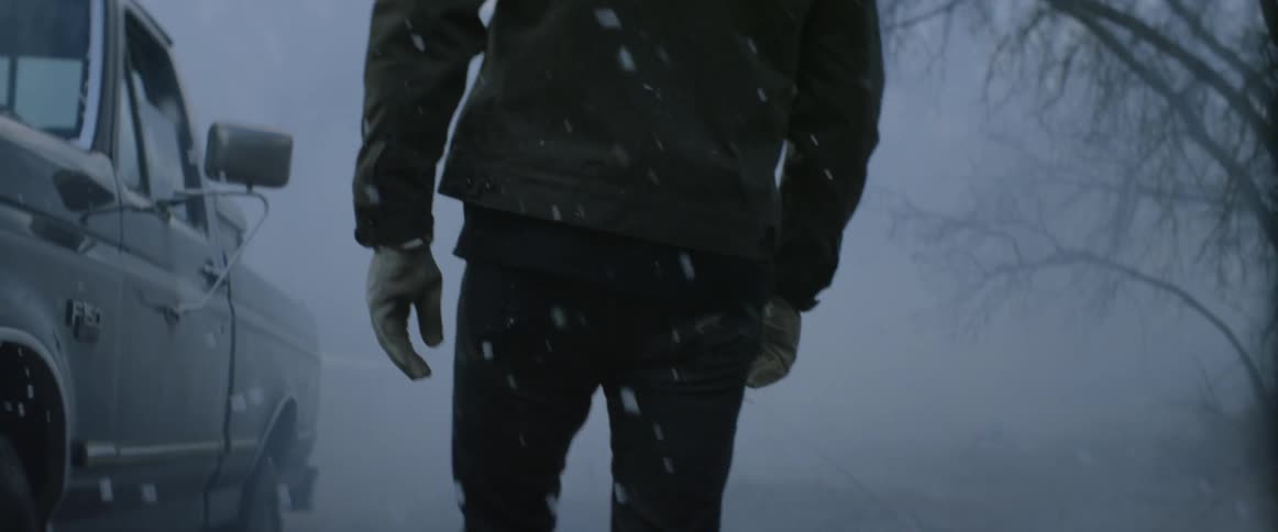 A man walks outside in the snow