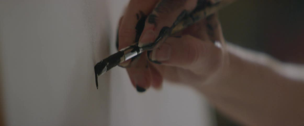 An artist paints on a canvas