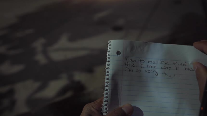 A person crumbles up a piece of notebook paper
