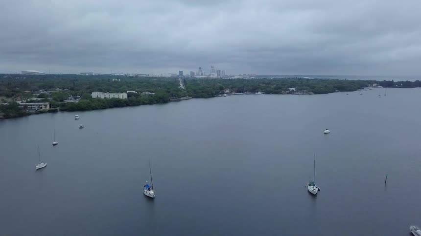 Boats float on a lake on a cloudy day