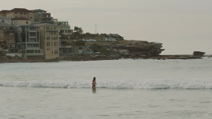 Woman jumps into ocean waves