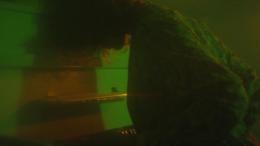 A woman leans against a piano