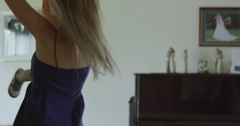 A woman swings around a toddler at home