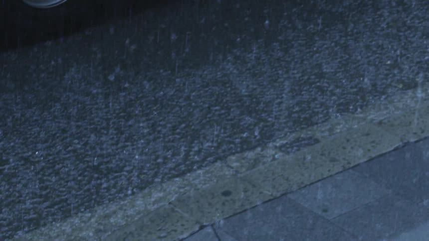 Raindrops falling on concrete
