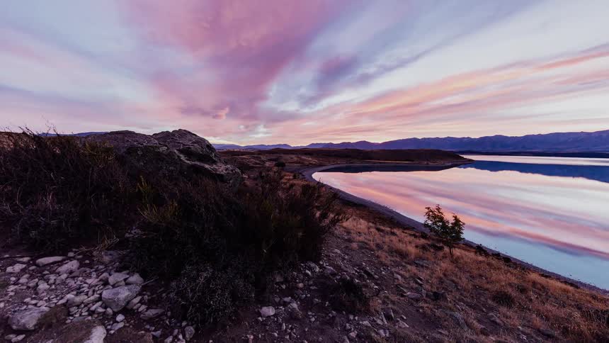 The colors of the clouds are reflected on the water's surface