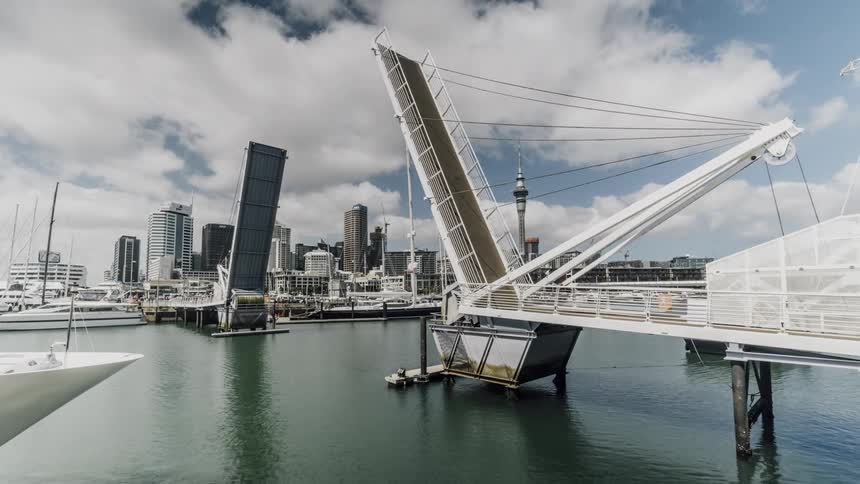 A bridge lifts as a boat sails beneath