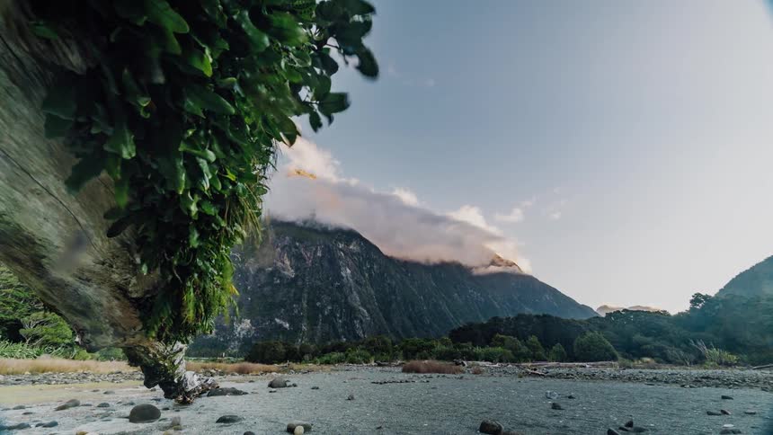 Clouds are drifting across a mountain during the day