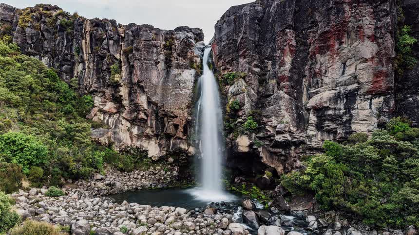A waterfall flows over a rocky cliff