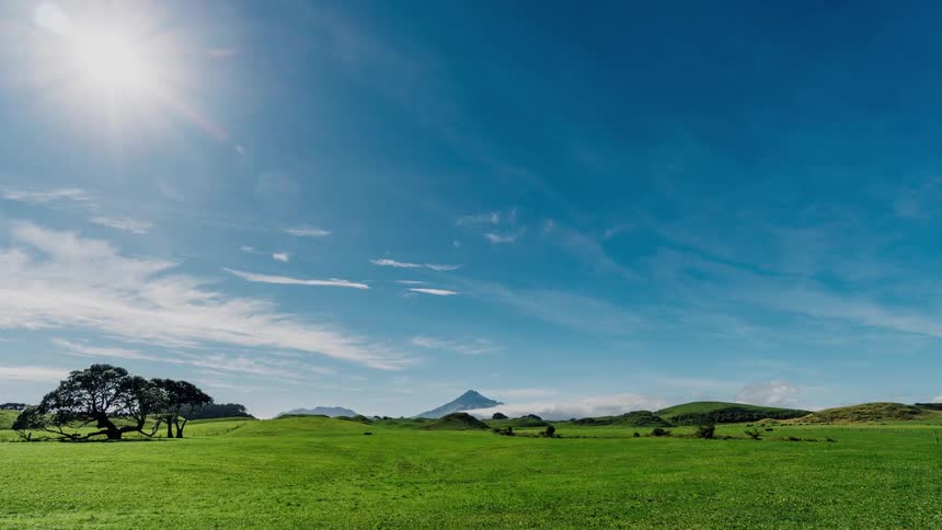 Clouds float over a rural grassy field