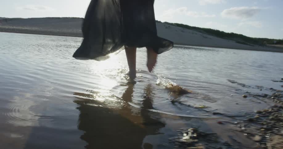 A person walking into a lake
