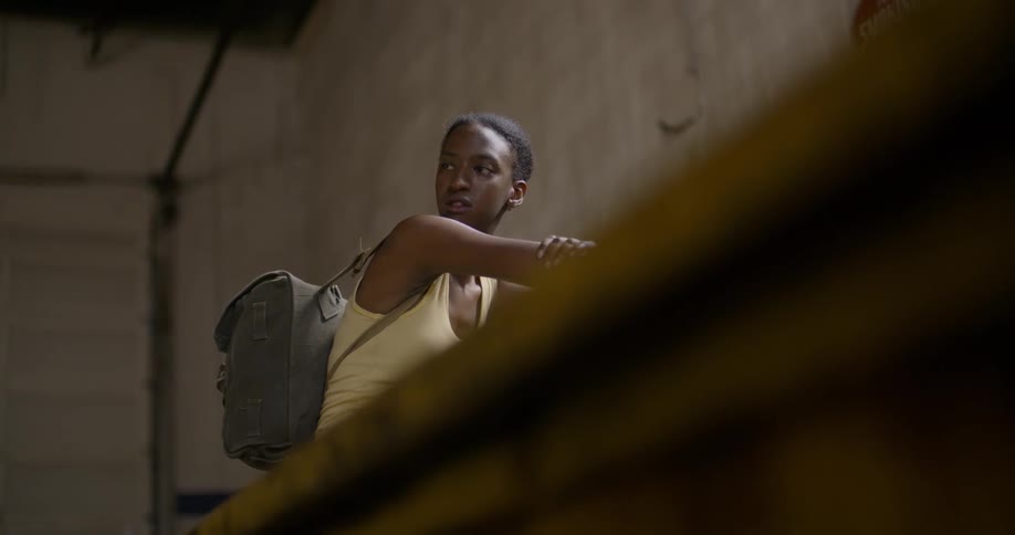 A woman is sitting inside and looking over her shoulder