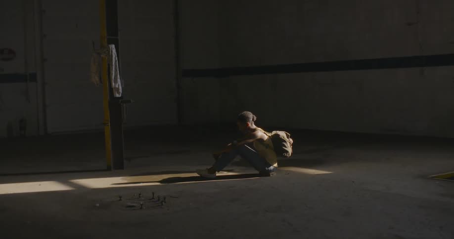 Someone is sitting inside a warehouse that's abandoned
