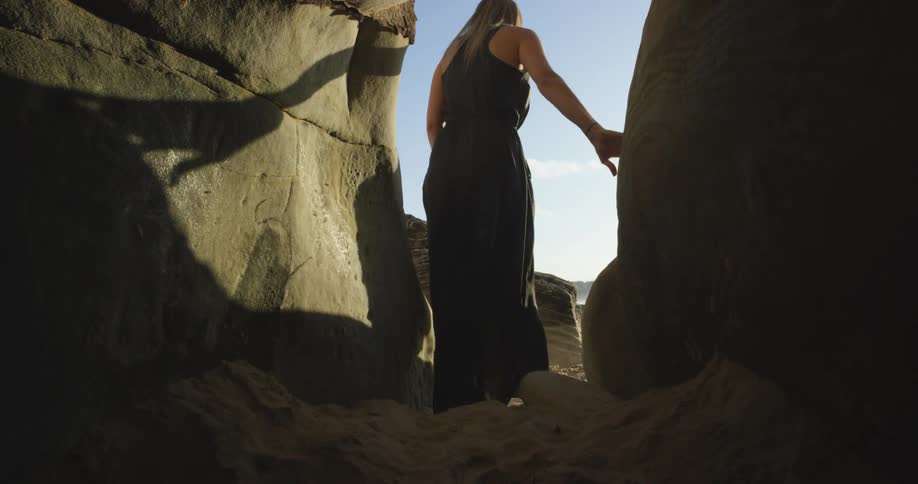 A person walking past some rocks