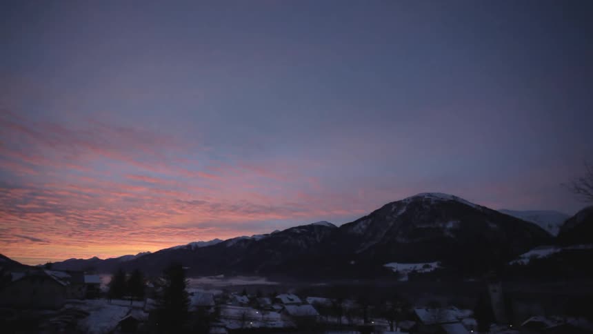 Sunset behind a snow capped mountain