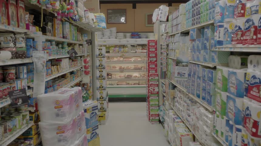 Child pushes a cart running through a grocery store