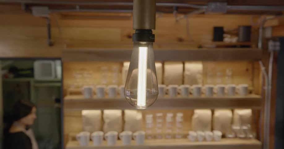 Woman turning on lights in a coffee shop