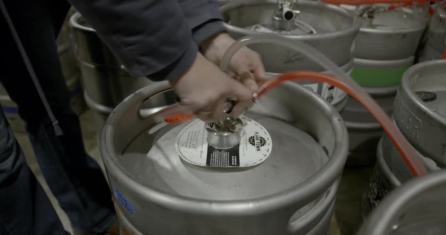 A man connects tubes to a barrel
