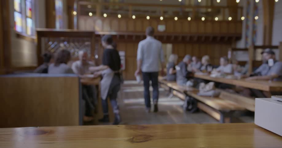 A man picks up a canned drink in a restaurant
