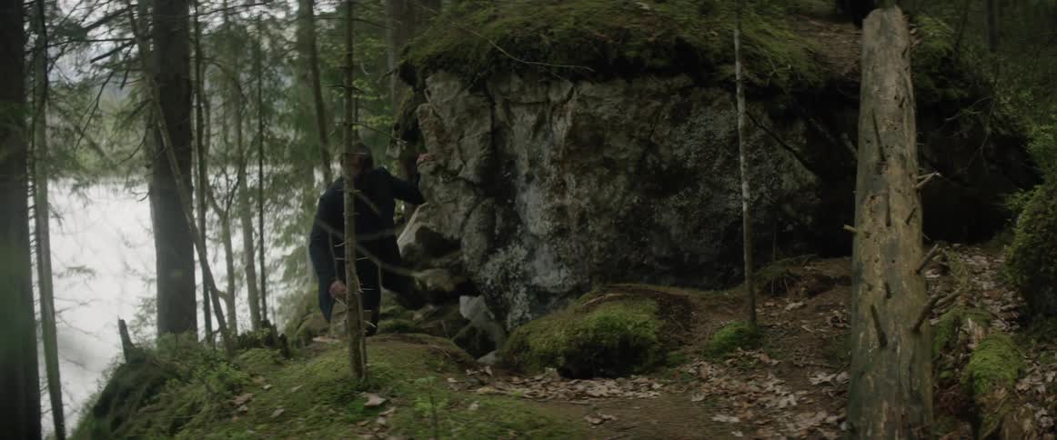 Man hikes through hilly rocky woods
