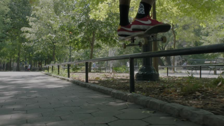 Man skateboarding in a park area using a rail for some tricks