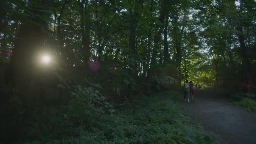 A couple put their arms around each other as they hike at dusk