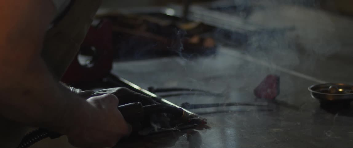 A man is using a welding torch to work on a piece of metal