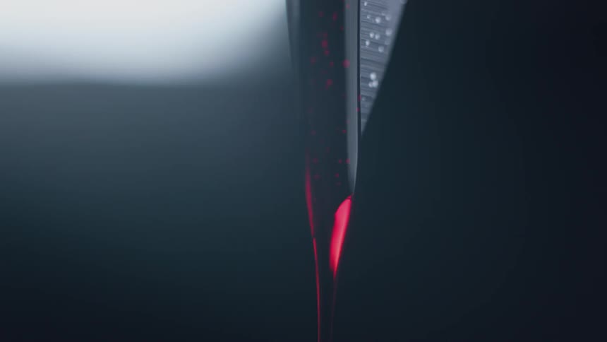A knife tip has blood dripping down it