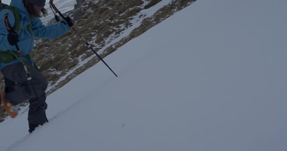 People are using walking sticks to get to the top of a snow covered mountain