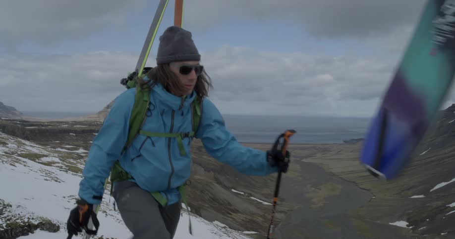 Two people are hiking up a snowy mountain