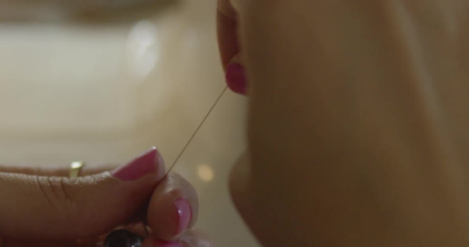 A person pulling thread on a spool