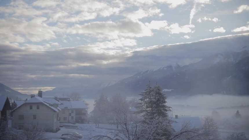 Clouds float over a winter mountain scene