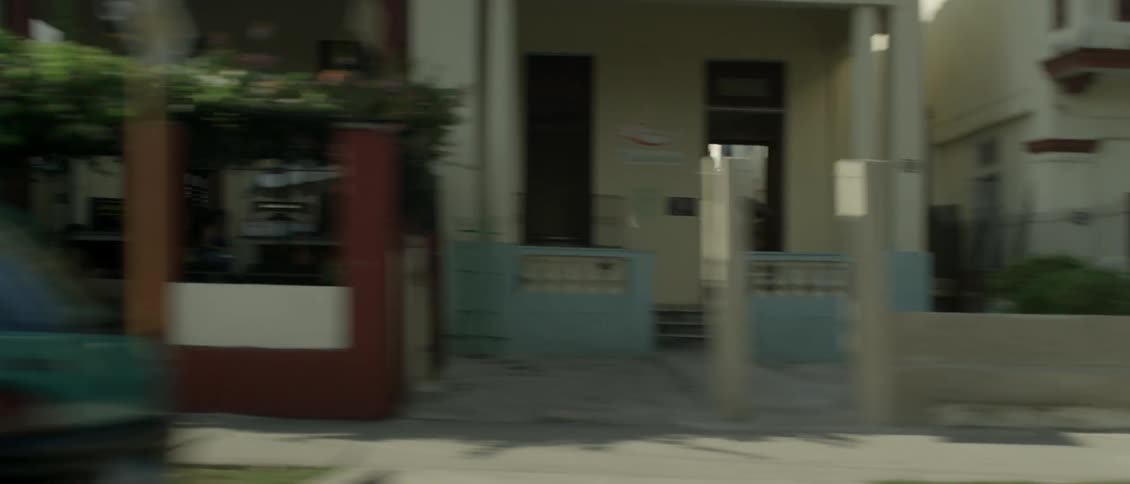 Houses line the streets as a car drives by
