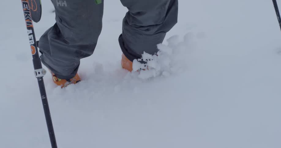 Skiers hike up a snowy mountainside