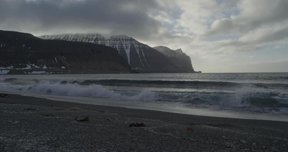 Waves come to shore on a cold cloudy day