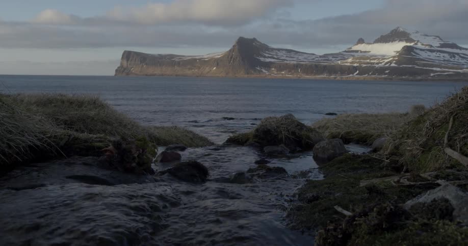 A view of an ocean with water flowing over rocks in timelapse