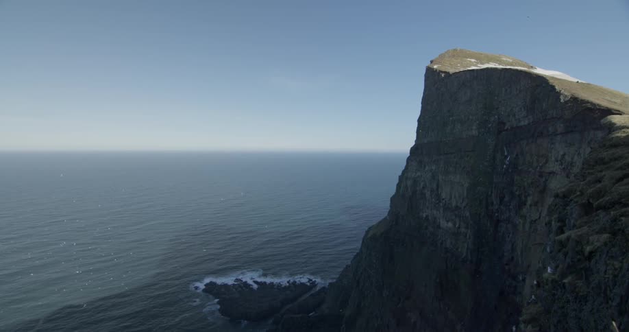 A large cliff drops down into the ocean