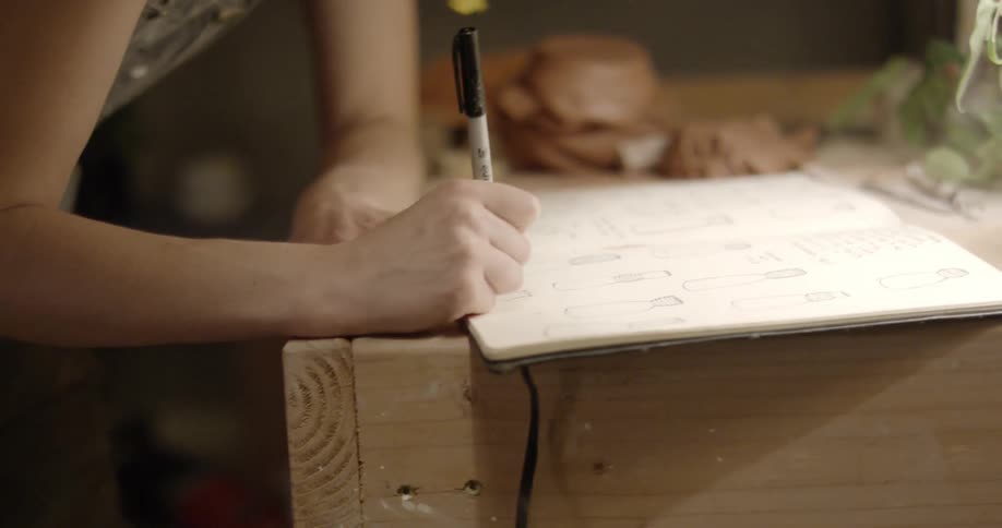 Woman writes on a dry erase board with a black marker